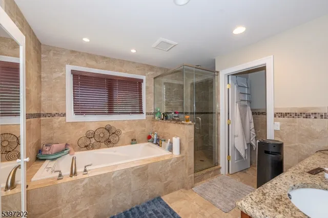 a spacious bathroom with a tub sink and mirror