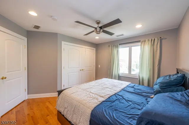 a bedroom with a large bed chandelier and a window