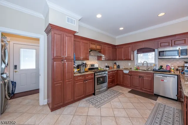 a kitchen with stainless steel appliances granite countertop a refrigerator and a sink