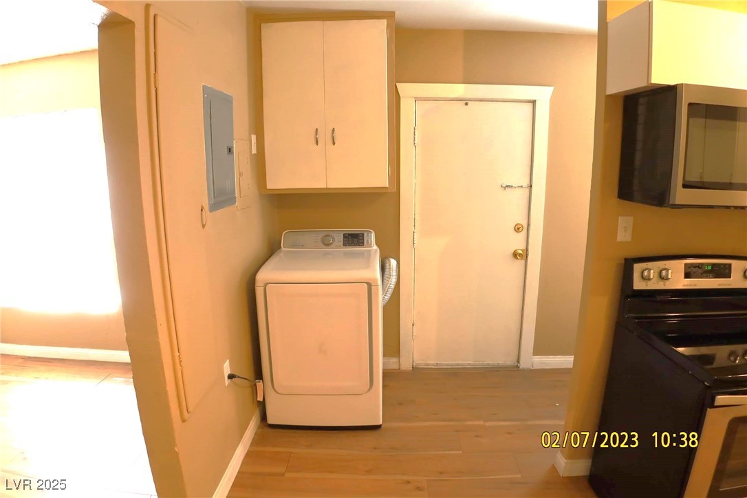 10 East Bonanza Road Las Vegas, NV 89101 - Photo 20 of 35 Laundry area with laundry area, light wood-type flooring, electric panel, baseboards, and washer / clothes dryer