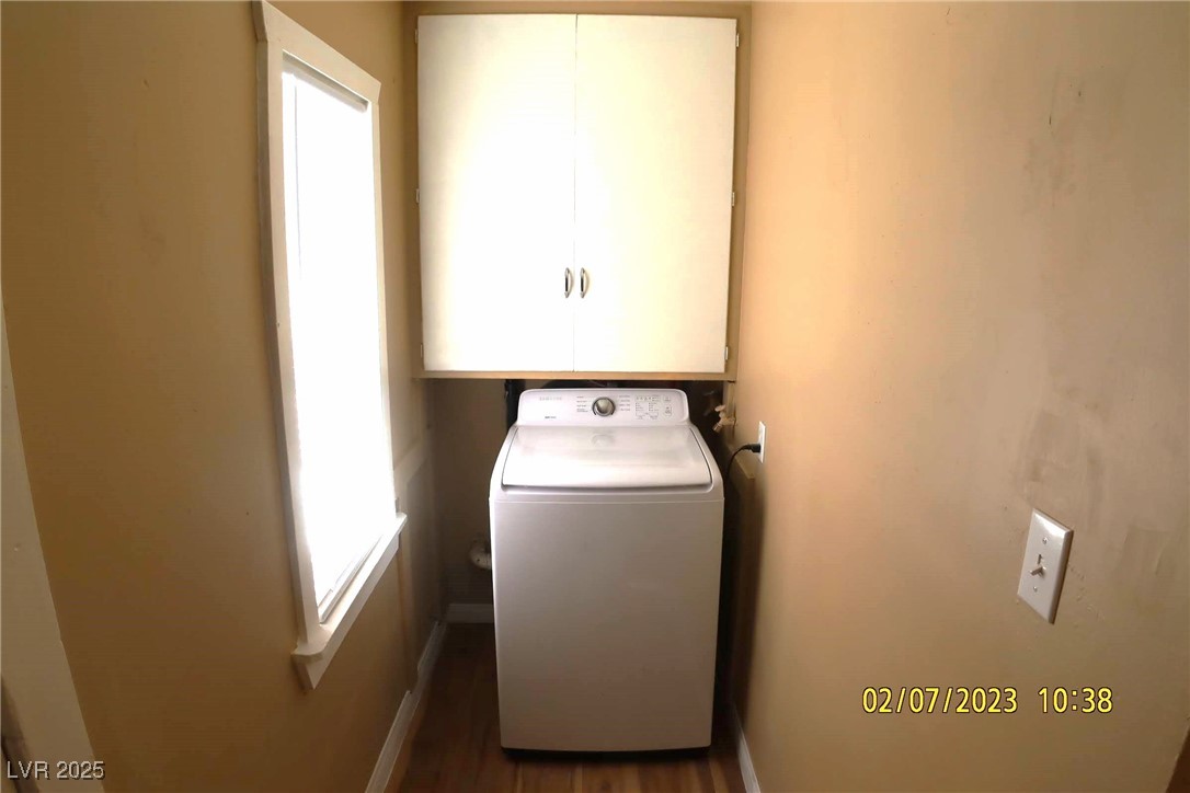 10 East Bonanza Road Las Vegas, NV 89101 - Photo 21 of 35 Laundry room featuring baseboards, washer / clothes dryer, dark wood-type flooring, and cabinet space