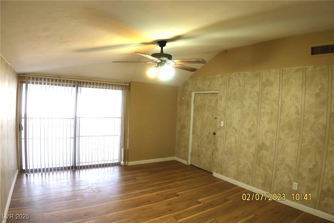 10 East Bonanza Road Las Vegas, NV 89101 - Photo 24 of 35 Spare room featuring baseboards, visible vents, lofted ceiling, a ceiling fan, and wood finished floors