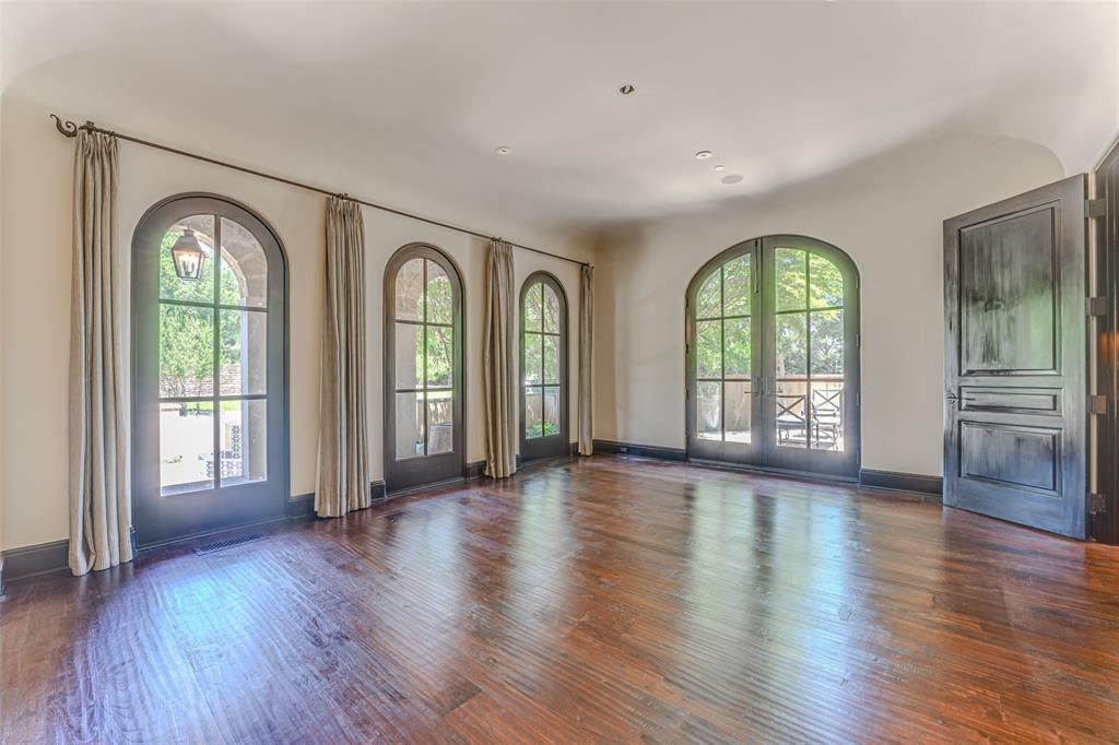 4120 Cochran Chapel Road Dallas, TX 75220 - Photo 9 of 39 an empty room with wooden floor a mirror and a floor to ceiling window
