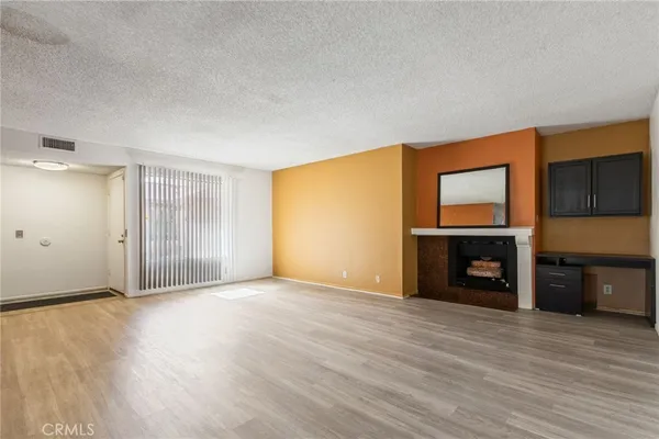 a view of an empty room with a fireplace and a window