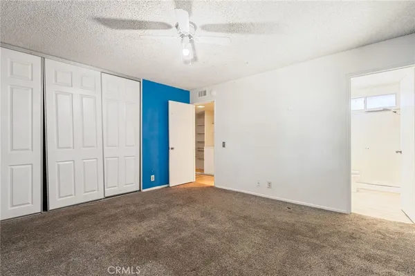 a view of an empty room with a ceiling fan