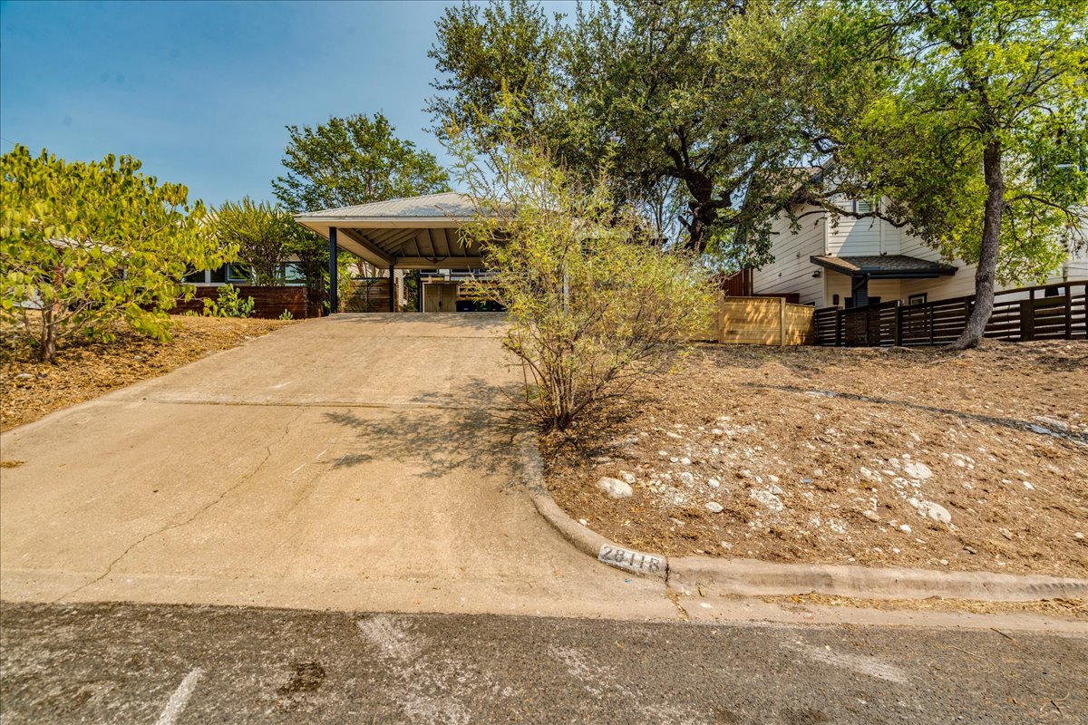 2811 Hardeman Street, Unit B Austin, TX 78704 - Photo 28 of 34 An inclined concrete driveway leads to a covered carport framed by mature native trees.