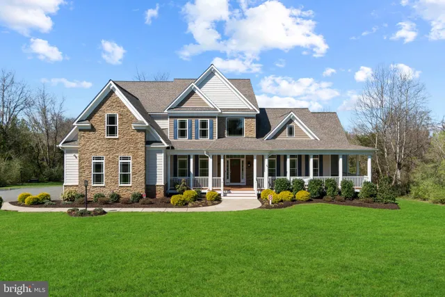 a front view of a house with a yard and potted plants