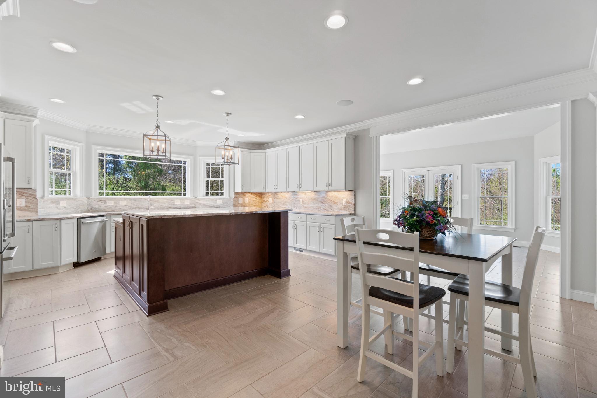 13725 Orlando Road Nokesville, VA 20181 - Photo 25 of 65 a kitchen with stainless steel appliances kitchen island granite countertop a table and chairs in it