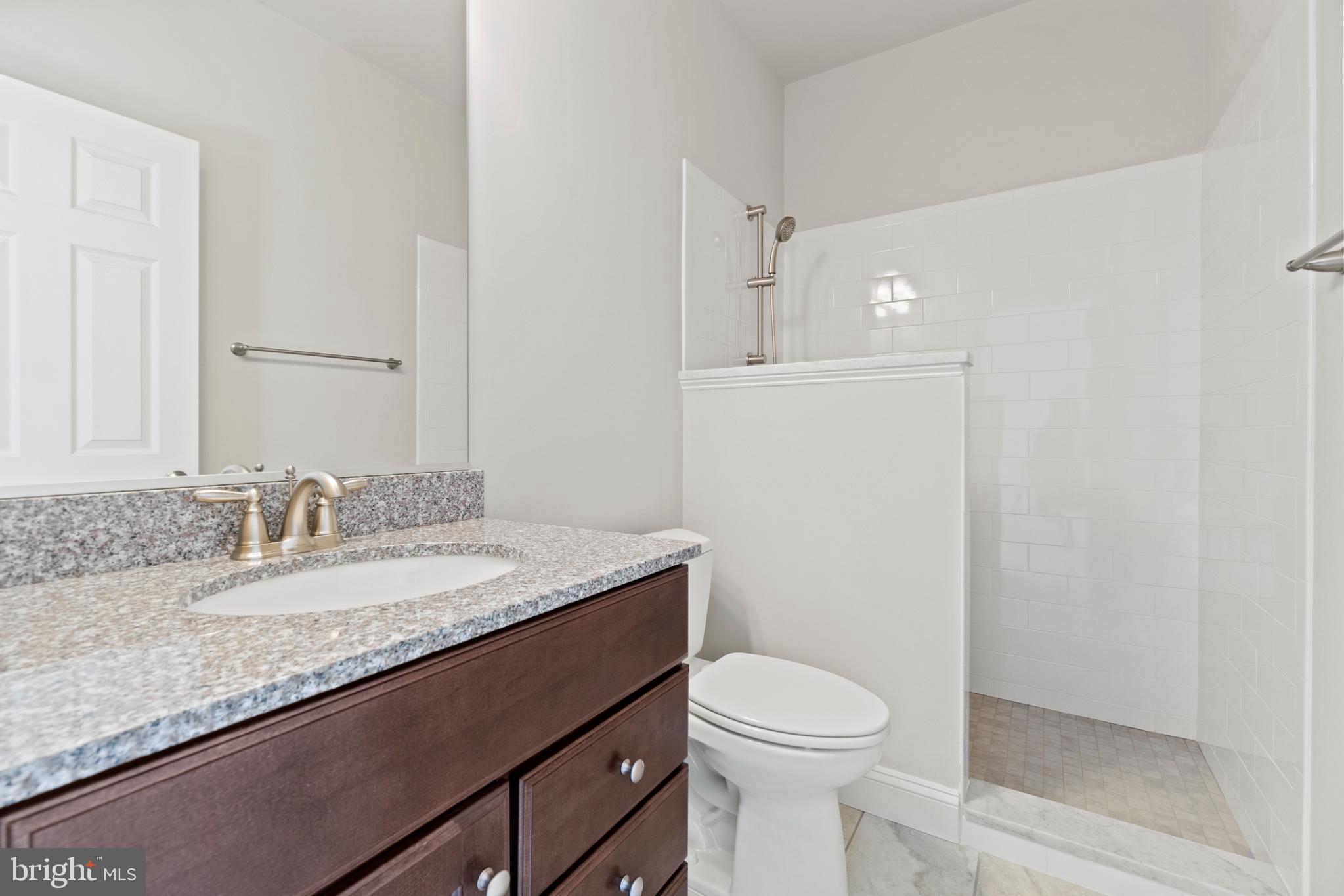 13725 Orlando Road Nokesville, VA 20181 - Photo 48 of 65 a bathroom with a granite countertop sink a toilet and a mirror