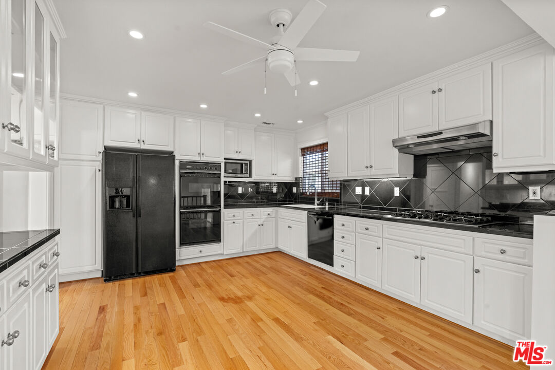 4352 Globe Avenue Culver City, CA 90230 - Photo 7 of 30 a kitchen with granite countertop a refrigerator and a stove top oven