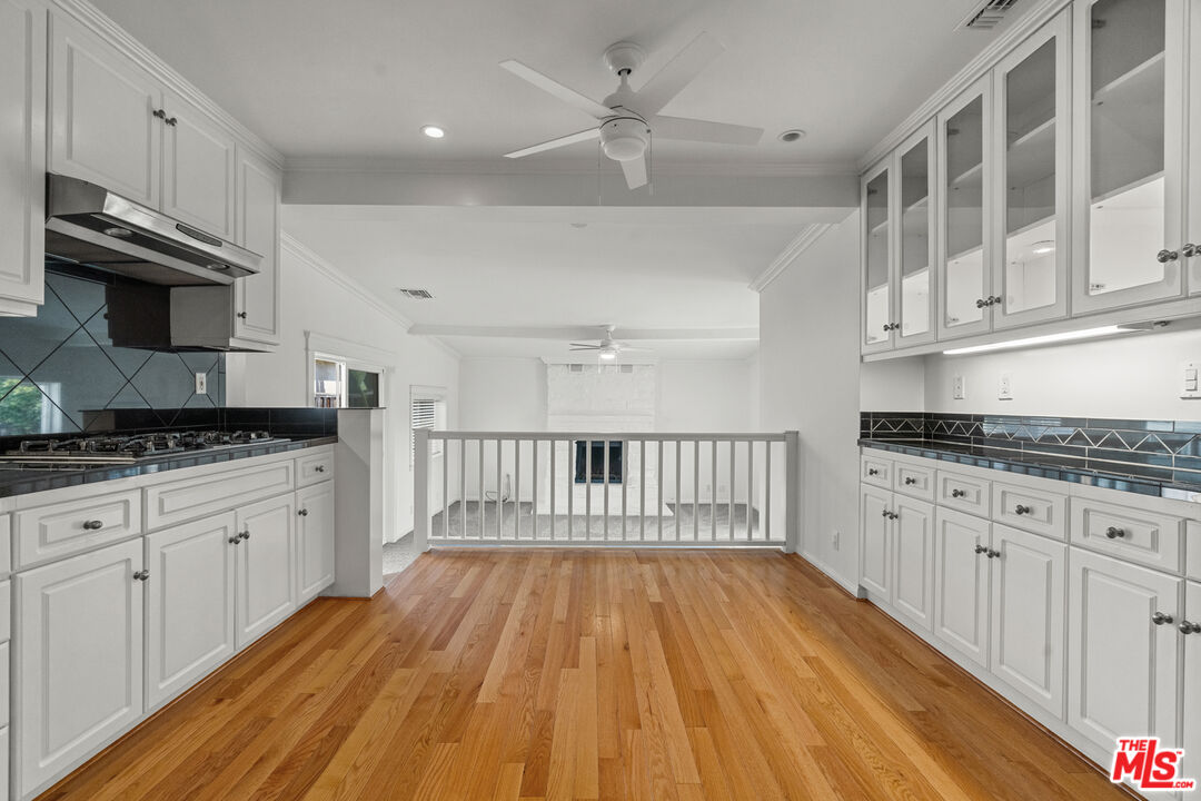 4352 Globe Avenue Culver City, CA 90230 - Photo 9 of 30 a kitchen with granite countertop a dishwasher a stove oven and white cabinets with wooden floor
