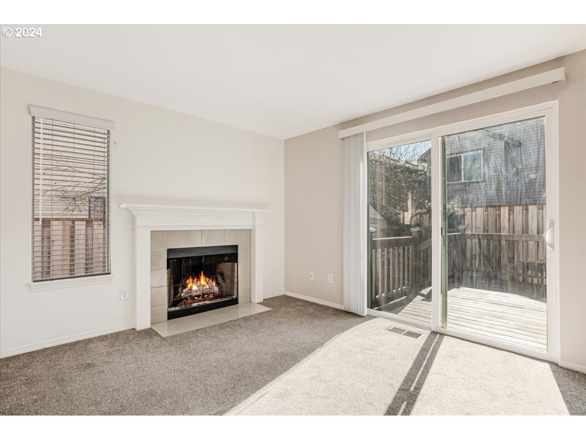 10570 Southwest Windsor Court Portland, OR 97223 - Photo 3 of 35 a living room with a fireplace and a floor to ceiling window