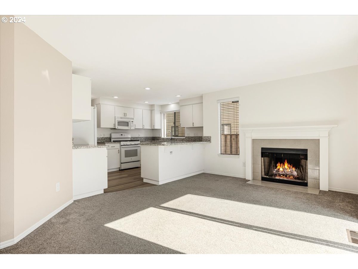 10570 Southwest Windsor Court Portland, OR 97223 - Photo 5 of 35 a view of a kitchen with a sink a fireplace and a window