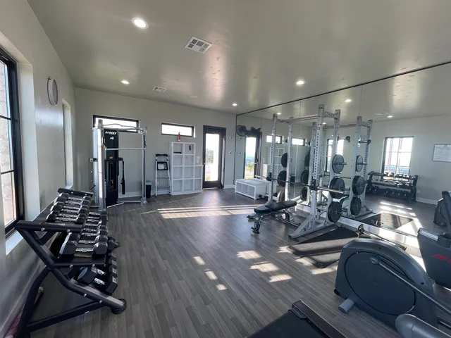 a living room with lots of furniture and gym equipment