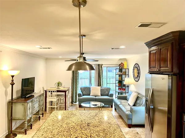 a living room with furniture a flat screen tv and a chandelier