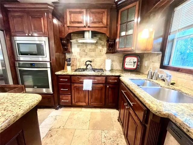 a kitchen with stainless steel appliances granite countertop a sink stove and refrigerator