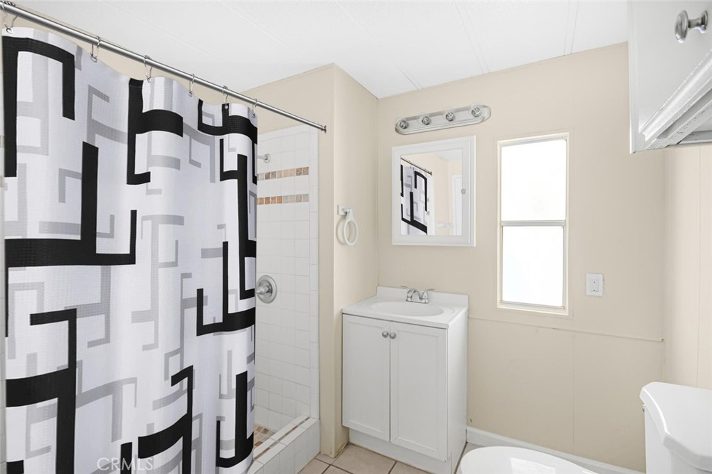 45131 28th Street East, Unit 19 Lancaster, CA 93535 - Photo 12 of 14 a bathroom with a shower a sink and a mirror