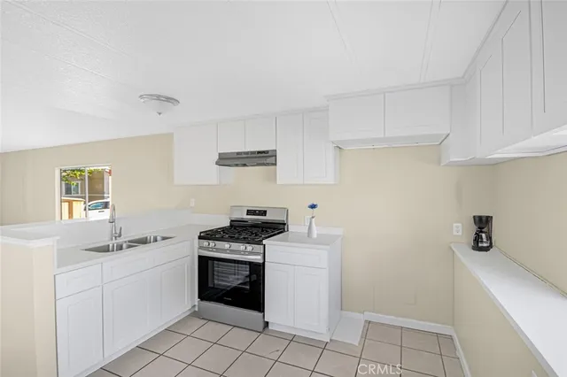 a kitchen with a stove sink and cabinets
