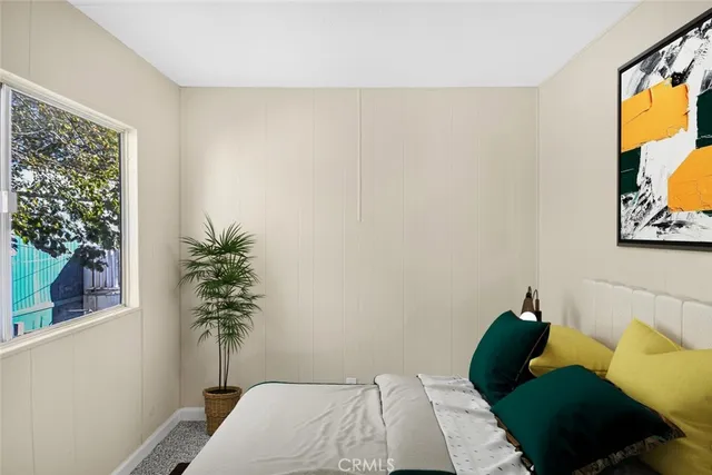 a bedroom with a bed and a potted plant