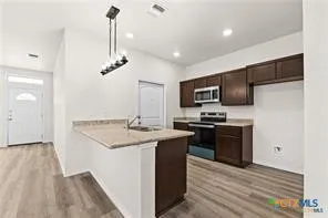 a kitchen with stainless steel appliances granite countertop a sink stove and refrigerator
