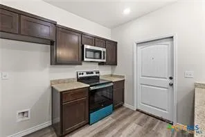 a kitchen with stainless steel appliances granite countertop a refrigerator and a stove top oven