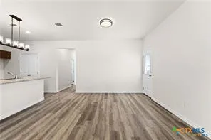 a view of a room with wooden floor and white walls