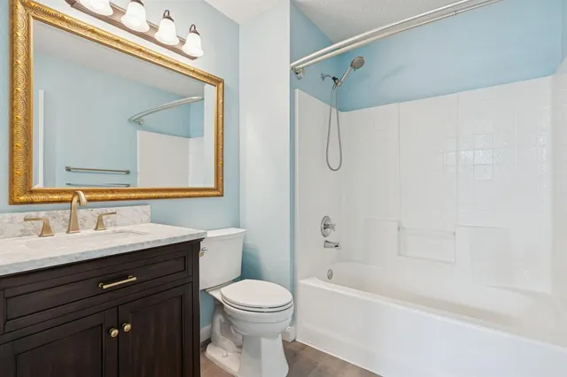 a bathroom with a bathtub sink vanity mirror and toilet