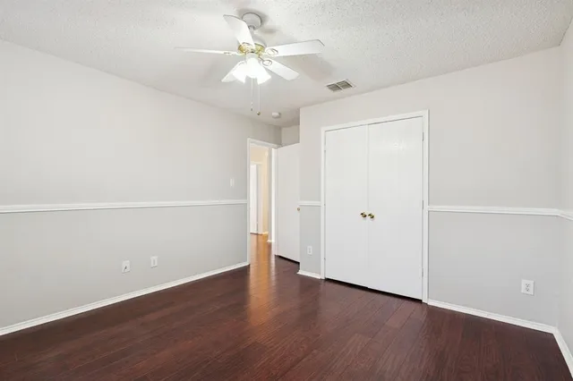an empty room with wooden floor and window