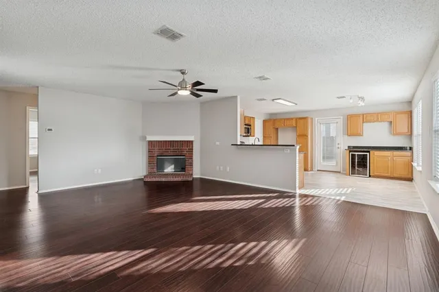 a view of a livingroom with wooden floor and a ceiling fan
