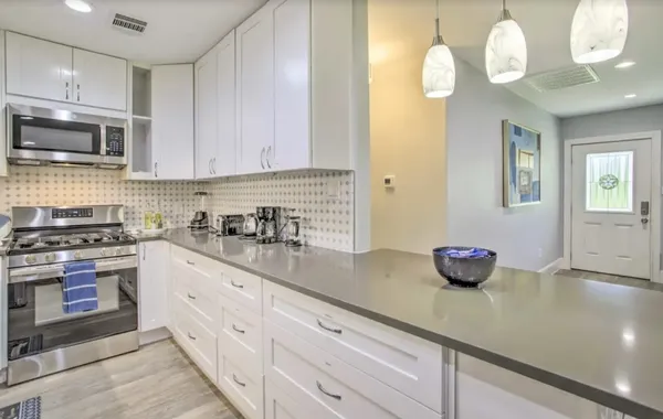 a kitchen with stainless steel appliances granite countertop a sink a stove and cabinets