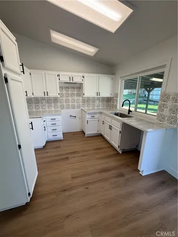 a kitchen with cabinets a sink and wooden floor