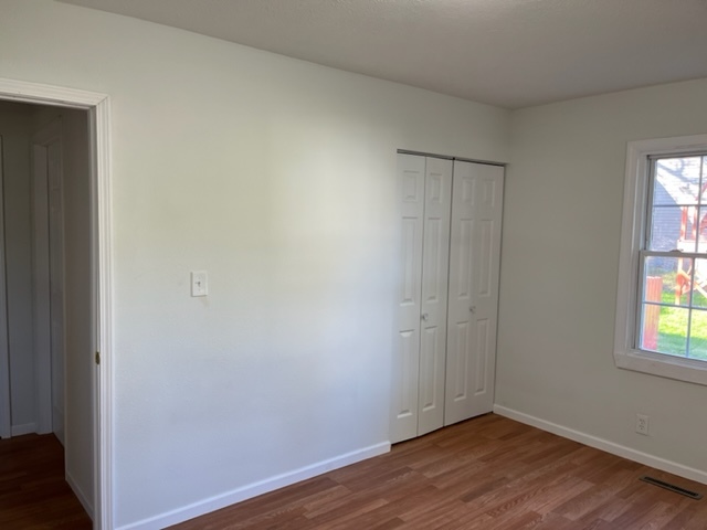 108 South 12th Street Rochelle, IL 61068 - Photo 9 of 17 an empty room with wooden floor and windows