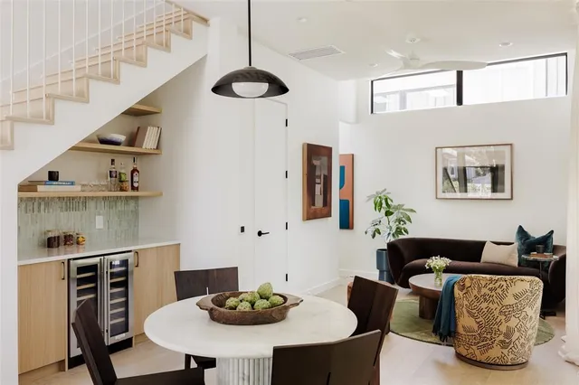 a living room with furniture kitchen view and a chandelier