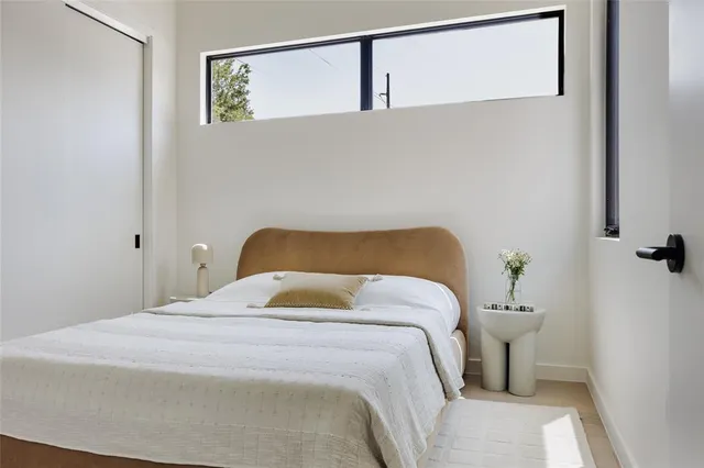 a bedroom with a bed and painting on the wall