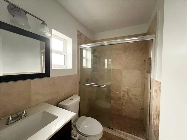 a bathroom with a sink mirror toilet and shower