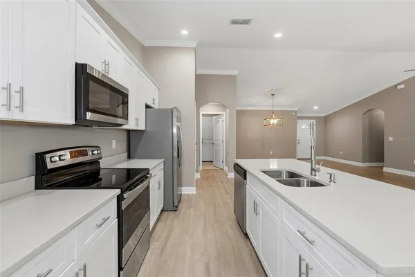a kitchen with stainless steel appliances granite countertop a sink a stove and a refrigerator
