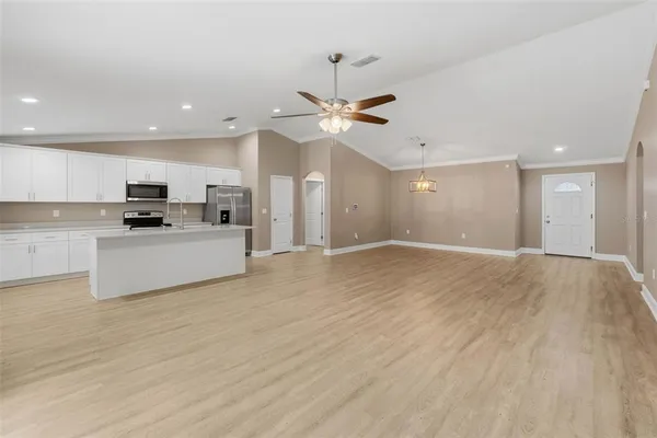 a view of kitchen with granite countertop cabinets and refrigerator