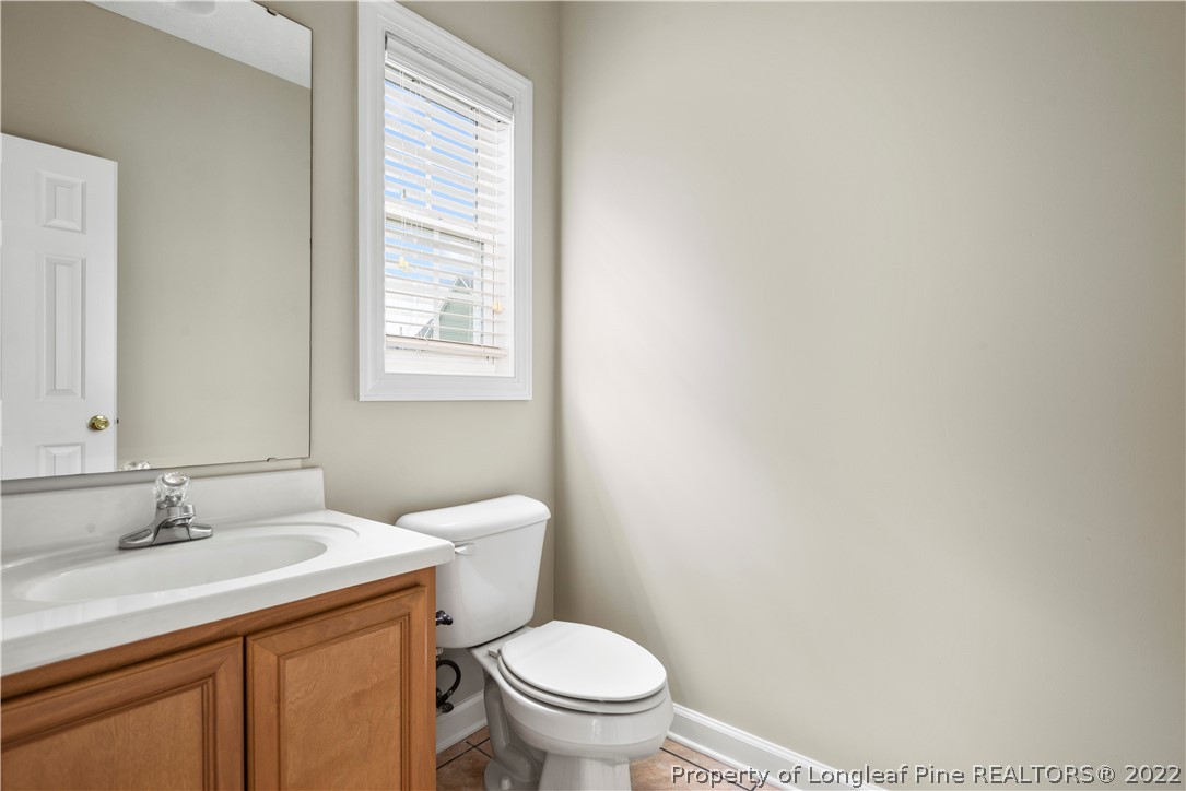 3612 Talus Road Fayetteville, NC 28306 - Photo 18 of 29 a bathroom with a granite countertop toilet a sink and a window