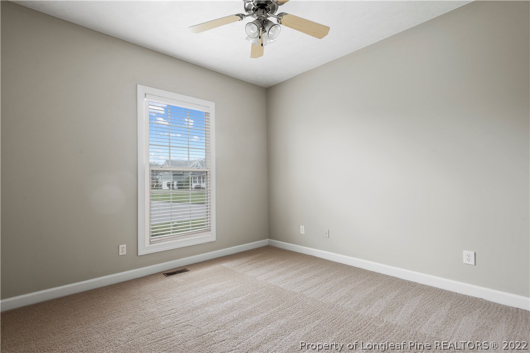 3612 Talus Road Fayetteville, NC 28306 - Photo 26 of 29 an empty room with a ceiling fan and windows