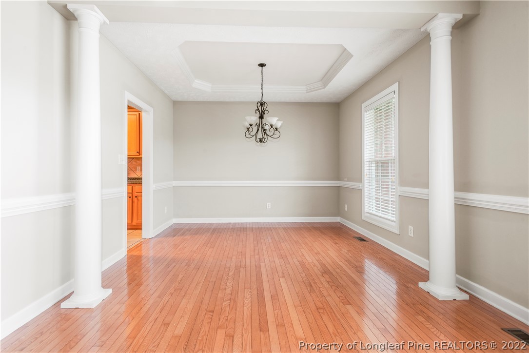 3612 Talus Road Fayetteville, NC 28306 - Photo 10 of 29 an empty room with wooden floor cabinet and windows