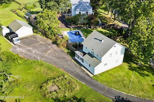 an aerial view of a house with swimming pool and lake view