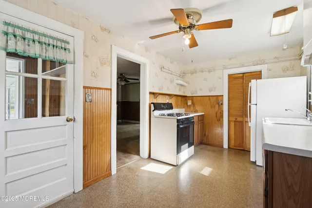 a kitchen with a refrigerator and white cabinets