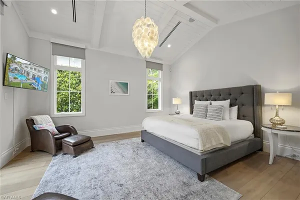 a bedroom with a bed and a chandelier