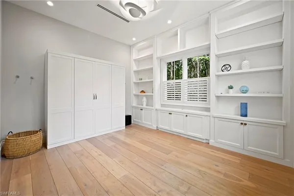 a view of an empty room with a window and wooden floor