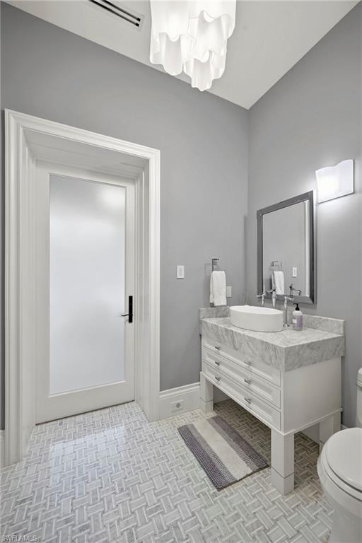 215 3rd Avenue North Naples, FL 34102 - Photo 19 of 47 Half bath featuring vanity and toilet