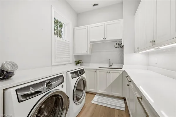 a utility room with sink dryer and washer