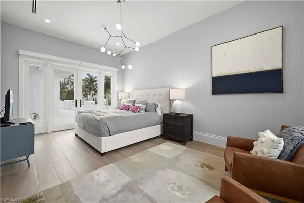 a bedroom with a bed a couch and a flat screen tv