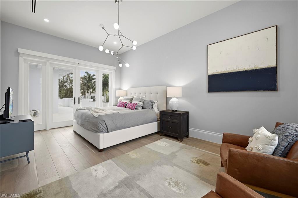 215 3rd Avenue North Naples, FL 34102 - Photo 25 of 47 Bedroom with light wood-type flooring, french doors, access to outside, hanging lights, and lofted ceiling