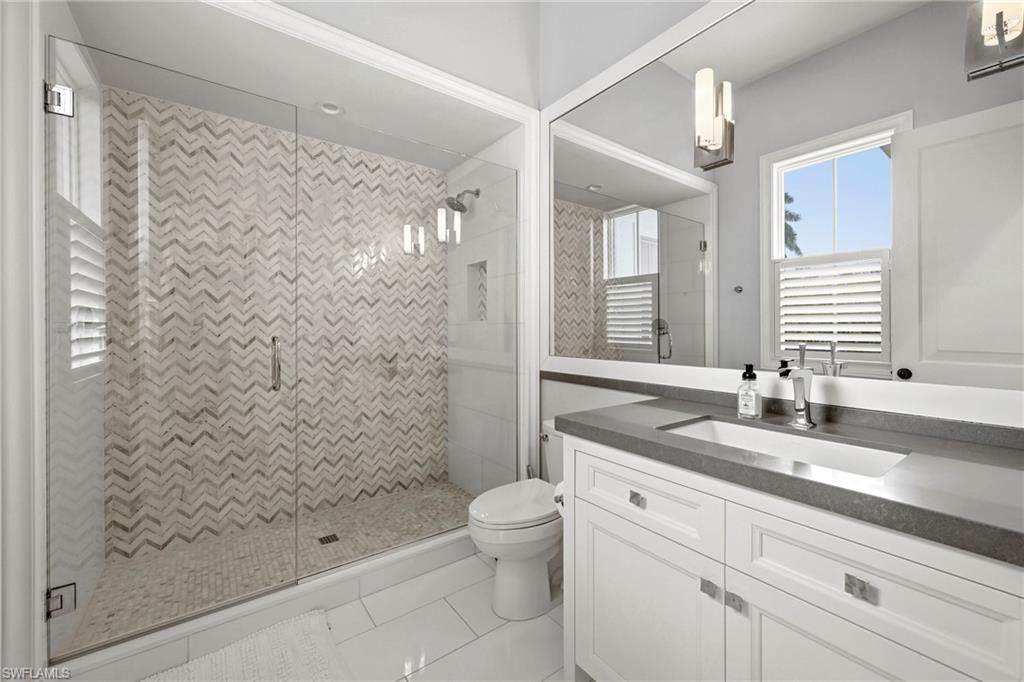 215 3rd Avenue North Naples, FL 34102 - Photo 27 of 47 Bathroom with a stall shower, vanity, and light tile patterned floors