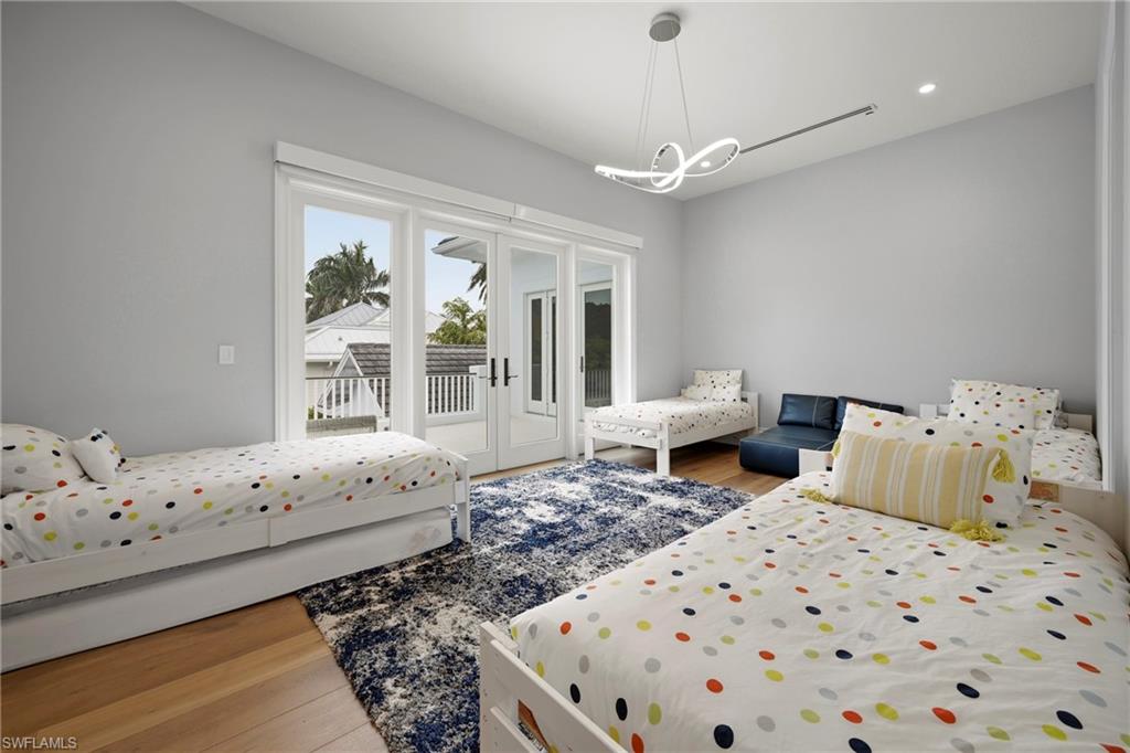 215 3rd Avenue North Naples, FL 34102 - Photo 28 of 47 Bedroom featuring light wood finished floors, access to outside, hanging lights, and french doors